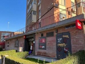 A building with a sign for 'Dia' and a mural with graffiti. - Stay in Quiet Madrid Area (Madrid)