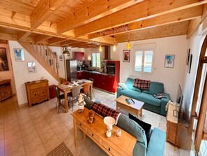 A cozy living area with a wooden dining table, a sofa, and a kitchen in the background. - Apartment With Mezzanine, Mont-dore (Mont-Dore)