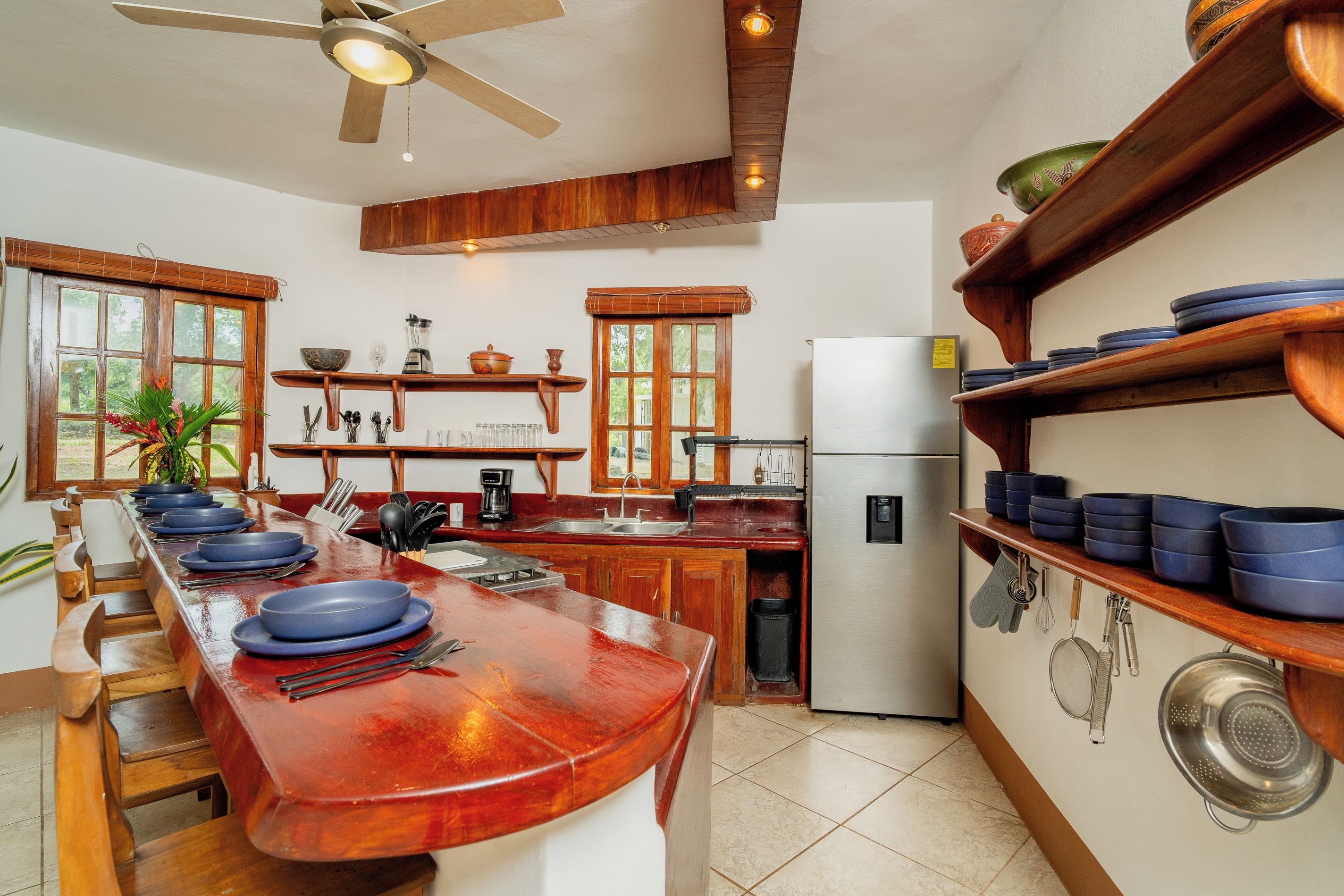 Una cucina con un bancone in legno, un frigorifero e un fornello.
