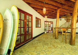 Un couloir décoré de planches de surf, avec des portes en bois et un escalier.
