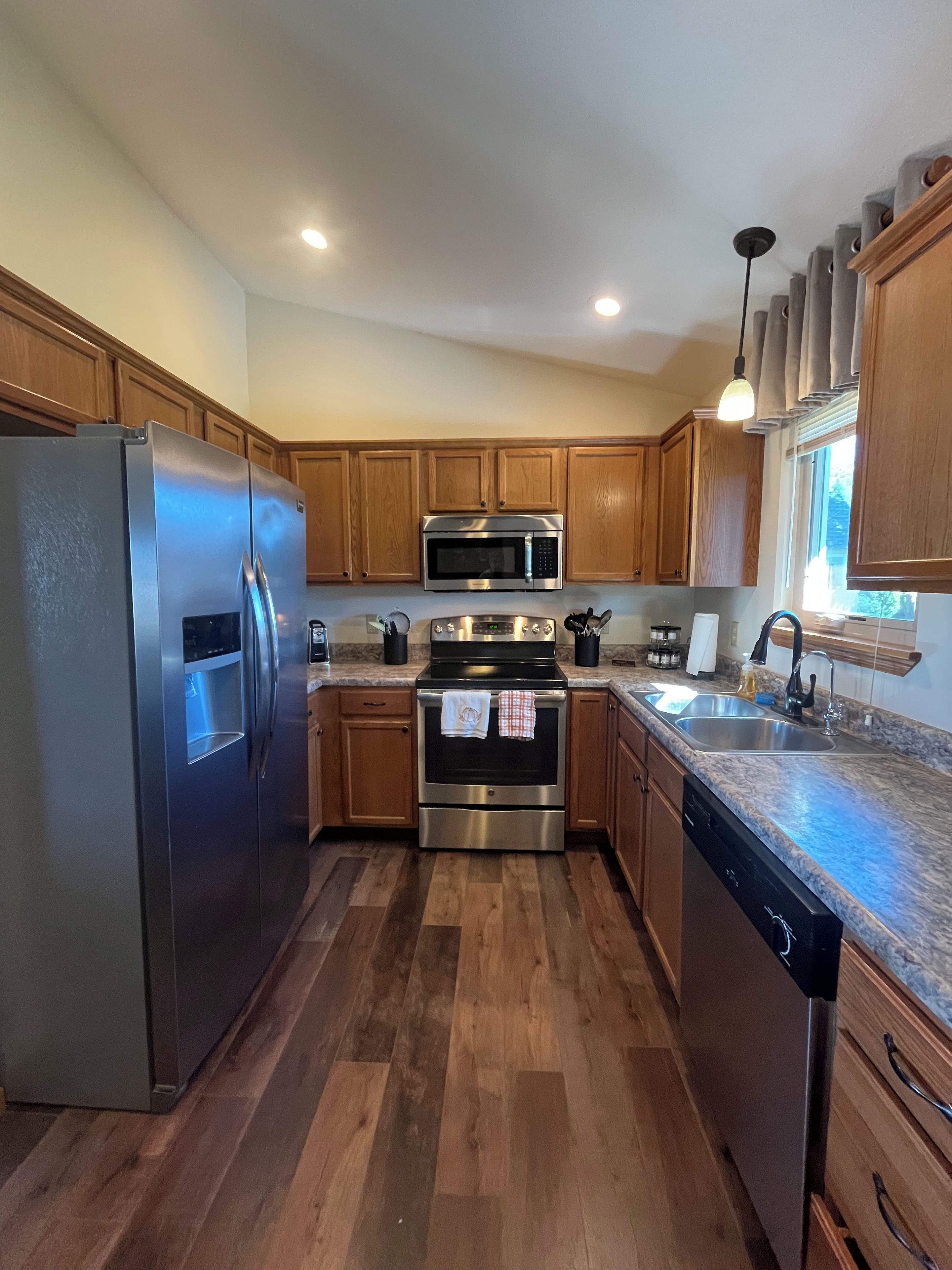 A kitchen with wooden cabinets, stainless steel appliances, and a granite countertop.