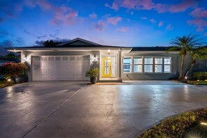 A single-story house with a garage, a front porch, and a large window. - Heated pool, hot tub, sauna, golf, theater, lounge (West Palm Beach)