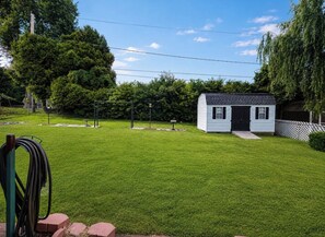 Une petite maison de plain-pied, dotée d’un porche à l’avant, entourée d’une pelouse bien entretenue et d’arbres.