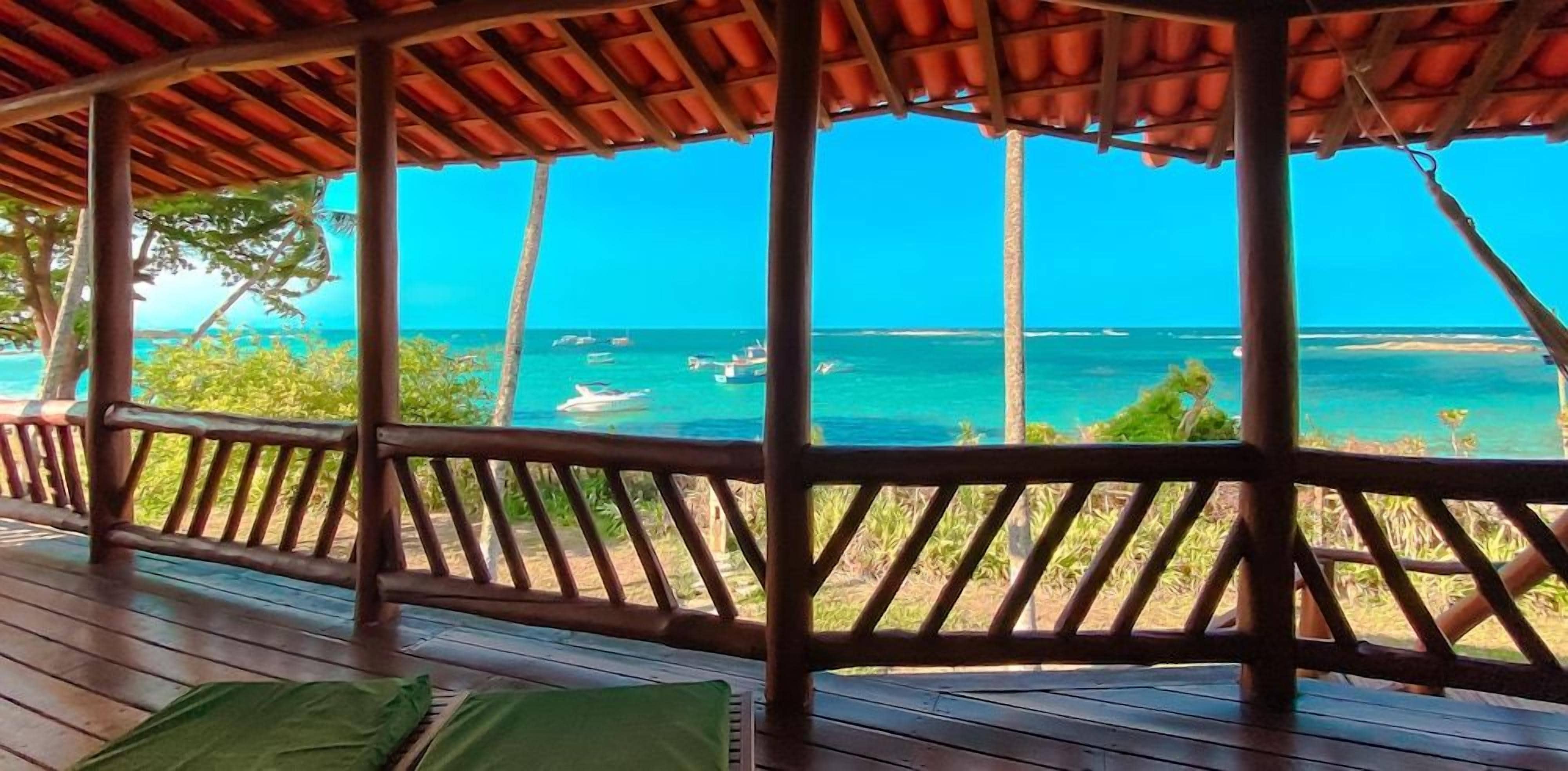 A wooden deck with a view of the ocean and boats.