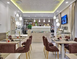 A modern restaurant with multiple dining tables and chairs, a bar area, and a television screen. - Relaxing Getaway in Zagreb for Couples (Zagreb)