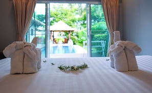 Ein Hotelzimmer mit Bett, Blick auf einen Pool und Vorhängen.