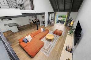 A modern living space with a sectional sofa, a round coffee table, and a flat-screen TV mounted on the wall. - Spacious Modern 3BR Home with Garage. Monthly Stays, Near DTC,Kid & Pet Friendly (Denver)