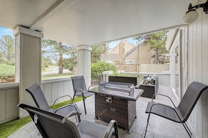 A covered patio with a table and chairs, a grill, and a view of a residential street. - Spacious Modern 3BR Home with Garage. Monthly Stays, Near DTC,Kid & Pet Friendly (Denver)