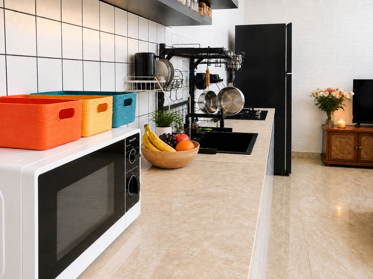 A modern kitchen with a microwave, a fruit bowl, and a dish rack.