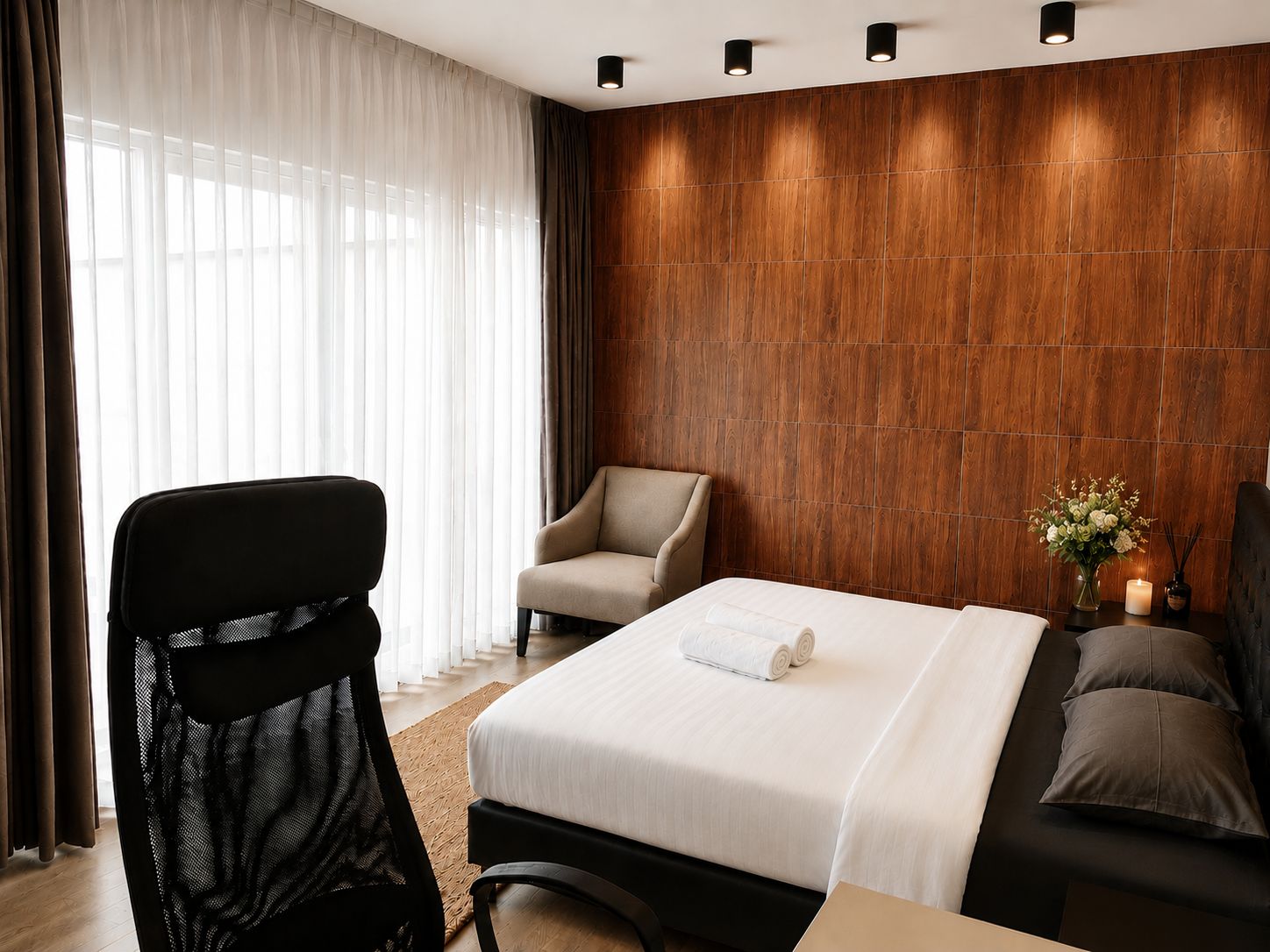 Een hotelkamer met een bed, een stoel, een bank en een houten wand.