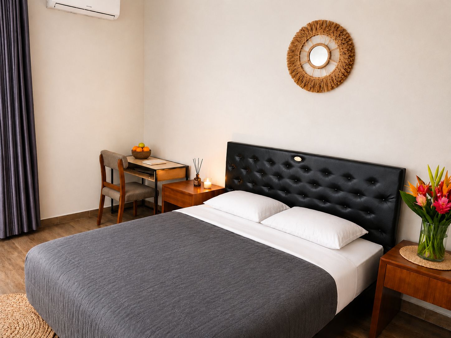 Une chambre d’hôtel comprenant un lit, un bureau, une chaise, une table de chevet, un climatiseur mural et un élément décoratif fixé au mur.