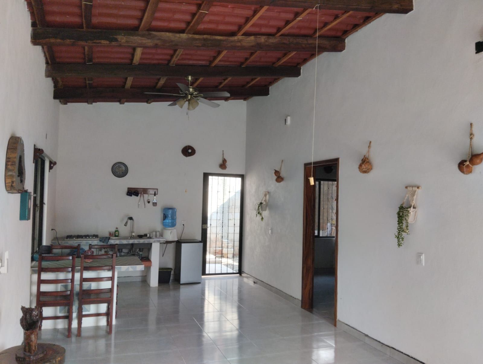 A spacious kitchen with a dining area, a ceiling fan, and a water dispenser.