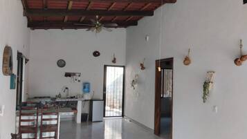 A spacious kitchen with a dining area, a ceiling fan, and a water dispenser.