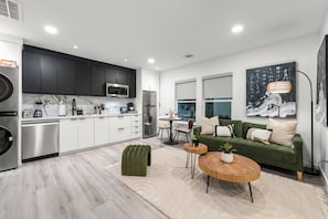 A modern kitchen with dark cabinets, stainless steel appliances, and a marble backsplash. - 2-bedroom Duo apartment in marvelous Dallas with AC and fitness room (Dallas)