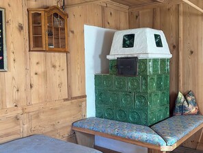 A wooden cabin interior with a green and white wall unit, a bench, and a wooden cabinet. - Schwaighof by Interhome (Auffach)