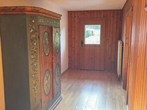 A hallway with wooden walls and a door leading to a room with a window. - Schwaighof by Interhome (Auffach)