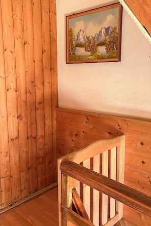 A wooden staircase with a wooden railing, a wooden wall, and a framed painting of a landscape. - Schwaighof by Interhome (Auffach)