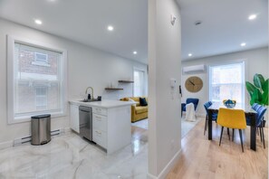 A modern apartment with a kitchen, dining area, and living space. - Westmount Gem 3BR • A/C • Wi-Fi • Laundry Inside • Near Metro & Parks (Westmount)