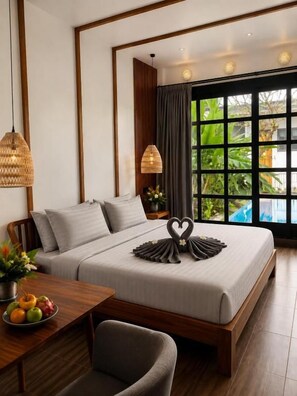 A modern bedroom with a large bed, a dining table with fruit, and a view of greenery through the window. - 1 Bedroom Norke Villa Gianyar (Gianyar)