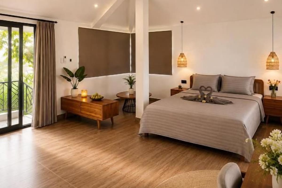 A modern bedroom with a bed, bedside tables, a ceiling fan, and a view of the outdoors.