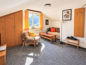 Una habitación acogedora con cama, una silla, una mesa y un armario.