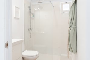 A bathroom with a shower, toilet, and a towel rack. - Your Loft in the Heart of Lanzarote: Charm, Tranquility, and Volcanoes (TINAJO)