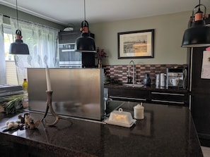 A kitchen with a stainless steel refrigerator, a coffee maker, and a microwave. - Country House Nestled Among Lakes and Fields (Nordwestuckermark)