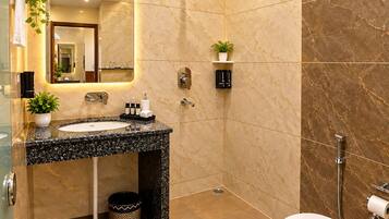 A modern bathroom with a marble vanity, a shower, and a toilet.