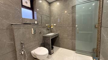 Un baño moderno con inodoro, lavabo y ducha.
