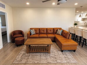 A living room with a brown leather sectional sofa, a wooden coffee table, and a brown leather ottoman. - Private Arcadia-Phoenix Escape with Resort-Style Backyard (Phoenix)