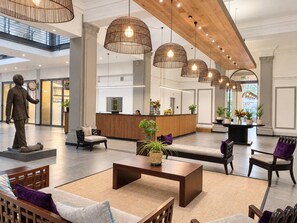 A spacious lobby with a reception desk, seating areas, and a statue. - New prospect Mandela Rhodes apartment (Cape Town)