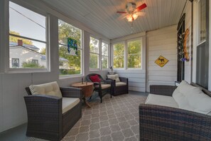 A sunroom with wicker furniture, large windows, a ceiling fan, and a wildlife crossing sign. - Cozy B&B Suite Near Finger Lakes & State Parks (Interlaken)