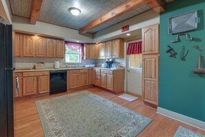 A kitchen with wooden cabinets, a dishwasher, a sink, and a window with a view. - Hike, Explore & Unwind: Finger Lakes B&B Suite (Interlaken)