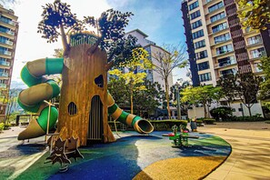 A playground with a spiral slide and a treehouse structure. - Sky Loft at Midhills Genting by HCK (Genting Highlands)