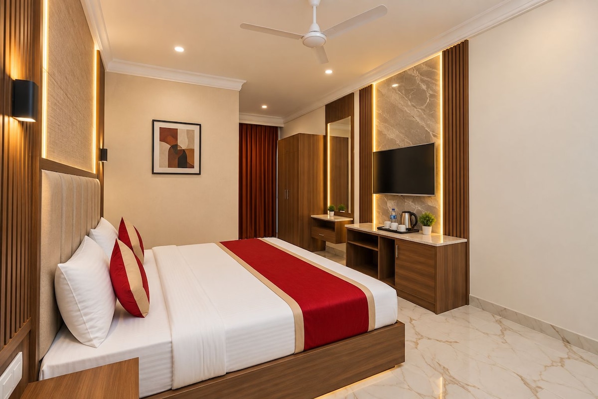 Una habitación de hotel con cama, escritorio, espejo y televisión.