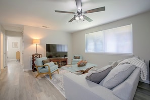 En stue med ventilator, fjernsyn, sofa og sofabord.