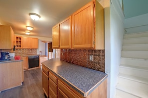 A kitchen with wooden cabinets, granite countertops, and a patterned backsplash. - Deck, Large Yard! Country Home in Mount Vision (Mount Vision)