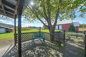 A wooden deck with a bench, a lattice fence, and a view of a red barn and green field. - Deck, Large Yard! Country Home in Mount Vision (Mount Vision)