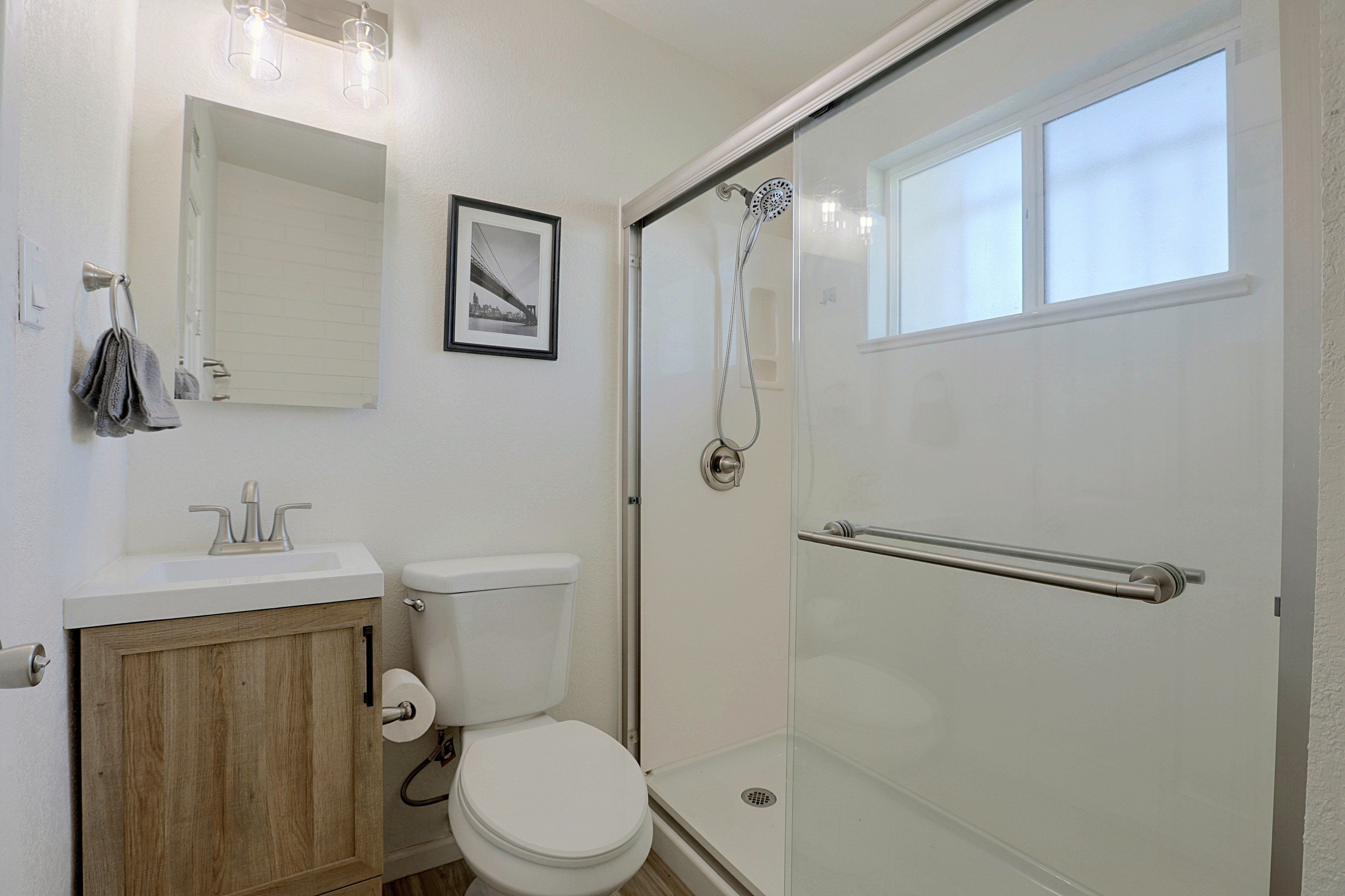 Une salle de bain avec des toilettes, un lavabo et une douche.