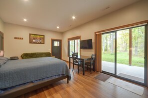 A bedroom with a bed, a desk, and a view of the outdoors. - Cozy Lakefront Retreat w/ Patio on the Big Chip (Hayward)