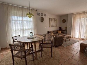 A living room with a round wooden table, wicker chairs, a sofa, and a coffee table. - L'Oneta Mediterranean charm by the sea (Badia de Xàbia)