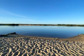 A calm lake with a sandy shoreline. - by the lake with private beach, fireplace and sauna (Löbnitz)
