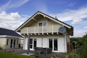 A two-story house with a balcony, a satellite dish, and a deck. - by the lake with private beach, fireplace and sauna (Löbnitz)