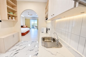 Quarto de hotel com cozinha, cama e vista para o exterior.