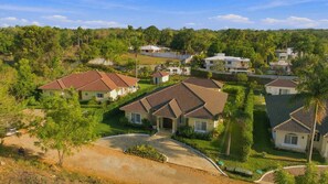 A residential area with houses featuring pitched roofs and a well-maintained lawn. - 4BR Caribbean Villa in Hispaniola (Sosúa)