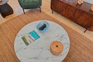A round marble coffee table with a remote control in a glass bowl, a magazine, and a wooden coaster. - 4BR Caribbean Villa in Hispaniola (Sosúa)