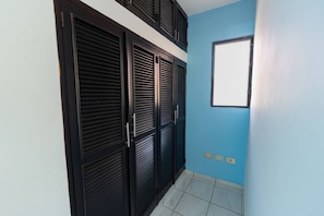 A hallway with a blue wall, a window, and a set of black doors. - Modern Sosua APT near beaches and cafe (Sosúa)