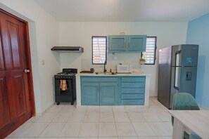 A compact kitchen with a stove, microwave, and refrigerator. - Modern Sosua APT near beaches and cafe (Sosúa)