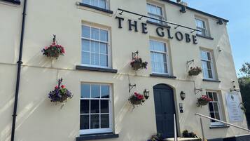 Un bâtiment portant l’enseigne « THE GLOBE », ce qui indique qu’il s’agit d’un pub ou d’un restaurant.