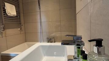 Une salle de bain moderne avec une baignoire, un lavabo et une douche.